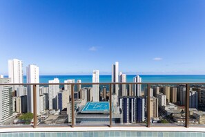 A high-rise building with a view of the city and the ocean.