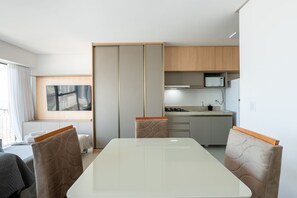 A modern kitchen with a microwave, stove, and sink. - Icon Housi in Boa Viagem New 300m From the Sea By Carpediem (Recife)