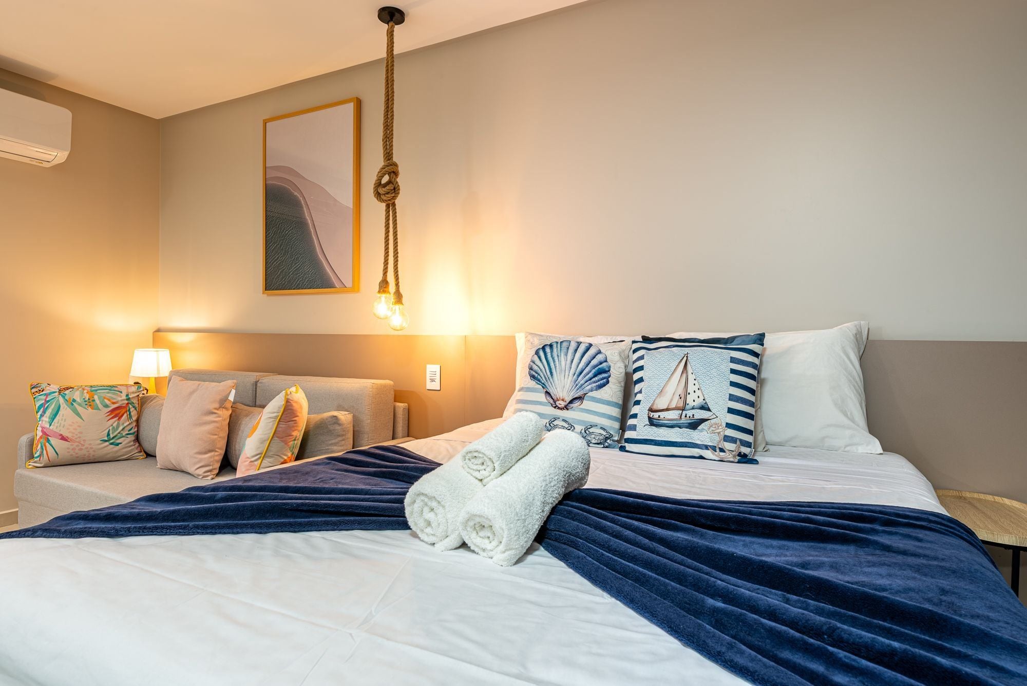 Ein Hotelzimmer mit einem Bett, zwei Nachttischen, einer Lampe und einem Bild an der Wand.