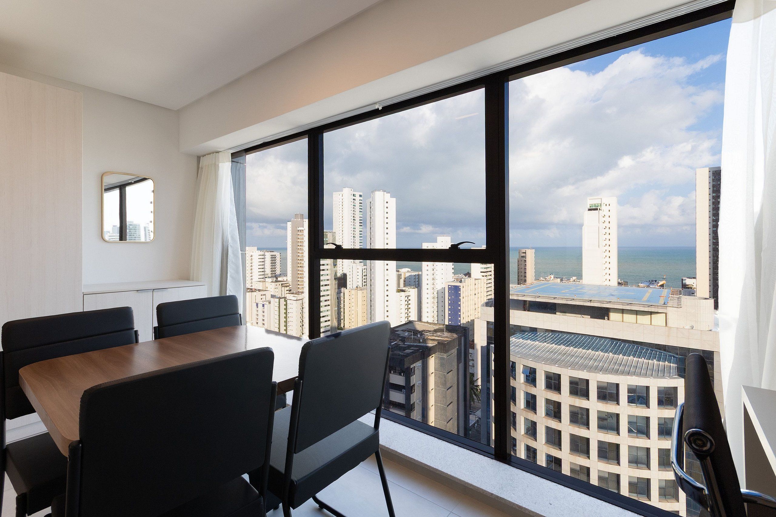 A modern hotel room with a large window offering a city view.