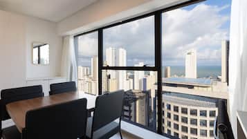 A modern hotel room with a large window offering a city view.