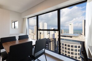 Ein modernes Hotelzimmer mit großem Fenster und Blick auf die Stadt.