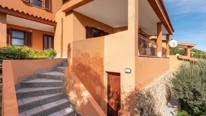 Un edificio a più piani con una scala in pietra che conduce a una porta in legno.