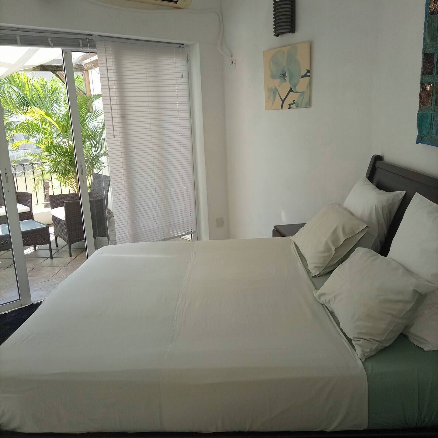 Une chambre à coucher avec un grand lit, une table de chevet et un tableau au mur.