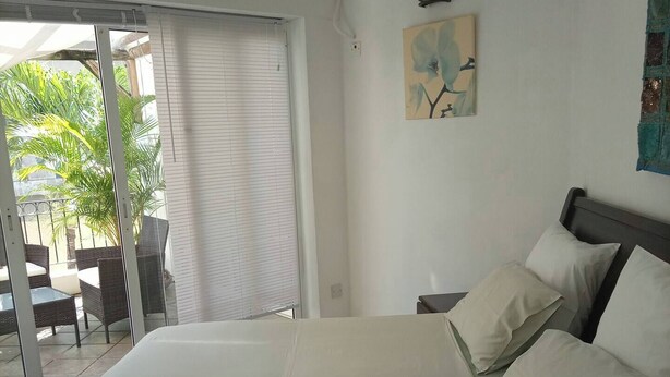 Una camera da letto con un letto grande, un comodino e un quadro appeso al muro.