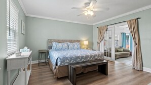 A bedroom with a bed, bedside table, lamp, bench, and a ceiling fan. - Lakehouse with Sunsets, Private Pool and Jacuzzi, 1Mi to Indian River Lagoon (Sebastian)