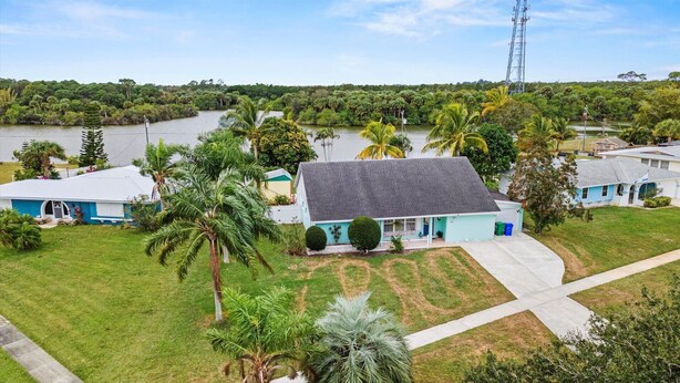 A residential area with houses, a river, and a power line tower. - Lakehouse with Sunsets, Private Pool and Jacuzzi, 1Mi to Indian River Lagoon (Sebastian)
