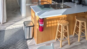 Une cuisine moderne avec des meubles en bois, des appareils électroménagers en acier inoxydable et un îlot central doté de tabourets.