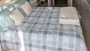 Une chambre avec un grand lit, une table de chevet, un miroir et une vue sur la salle de bain.