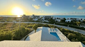 A resort with a pool, beachfront view, and modern architecture. - Luxury 3-Bedroom Villa with AC in Long Bay Hills Near Beach (Long Bay Hills)