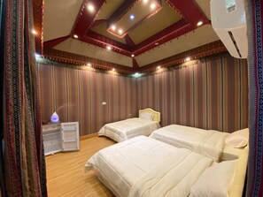 Ein Hotelzimmer mit zwei Betten, einem Nachttisch und einer dekorativen Lampe.