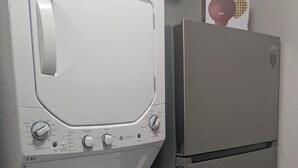 Una unitat compacta de rentadora i assecadora amb un frigorífic d'acer inoxidable.