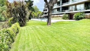 Un bâtiment moderne doté de nombreux balcons, d’une pelouse bien entretenue et d’une grande variété de plantes.