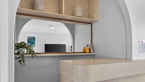 Een moderne badkamer met een grote spiegel, een wastafel en een plank met decoratieve objecten.