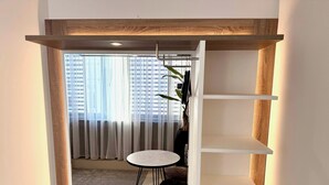 Ein moderner Wohnraum mit einer eingebauten Regaleinheit, einem kleinen runden Tisch und einer Mikrowelle.