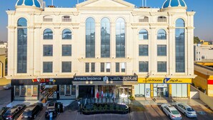 A large, classical building with a central dome and arched windows, featuring a pharmacy and a restaurant on the ground floor. - Armada Residence Hotel (Taif)