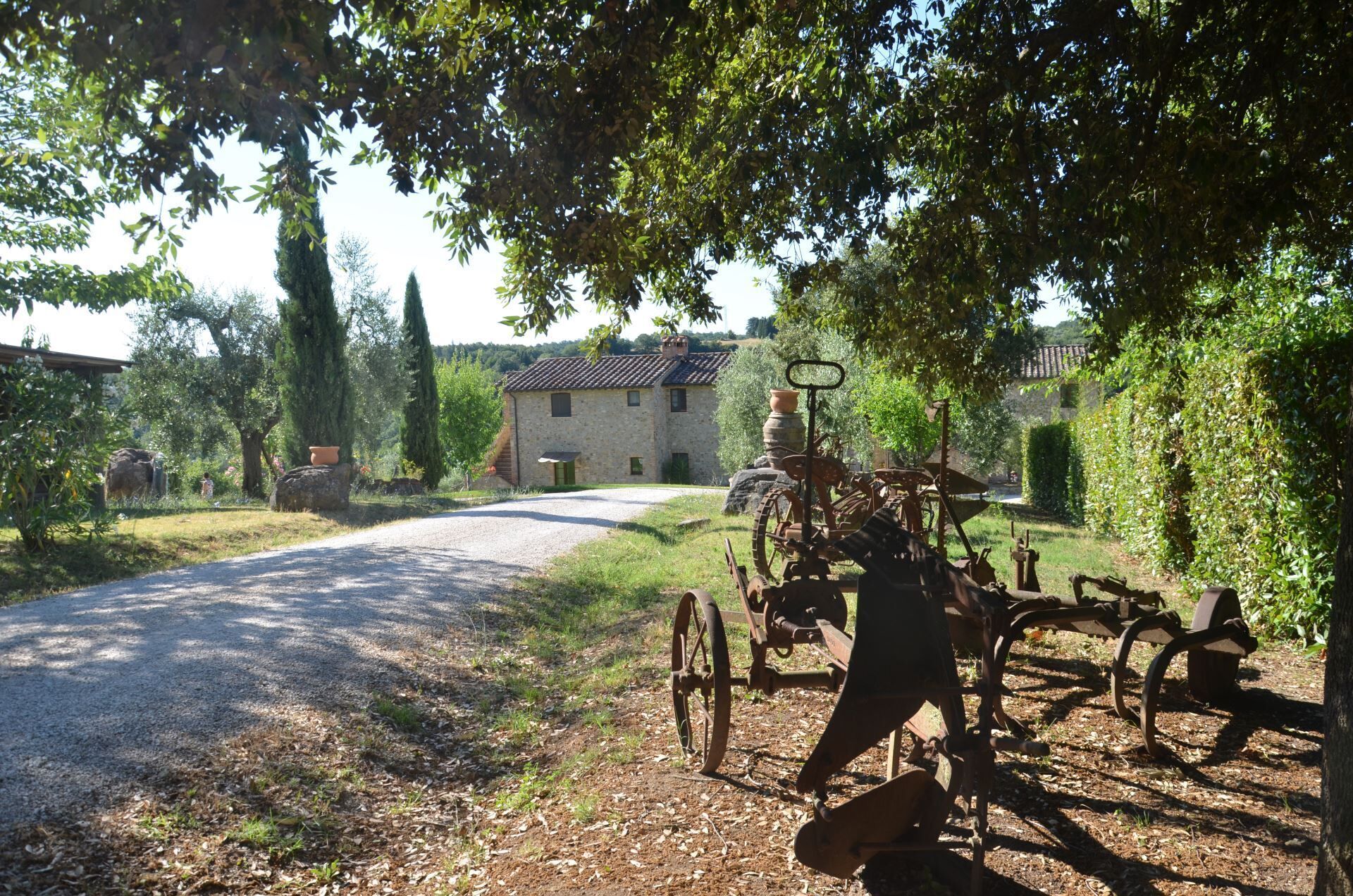 A rural road with a stone building and a vintage tractor in the foreground.