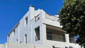 Un moderno edificio de dos pisos con techo plano, ventanas grandes y un balcón.