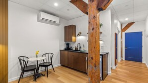 Une cuisine moderne avec des meubles en bois, un îlot central et un coin repas comprenant deux chaises.