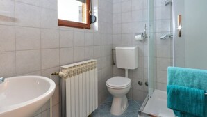 Kylpyhuone, jossa on pesuallas, wc ja suihku.