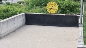 Betoninen ulkoalue, jossa on keltainen kello ja useita värikkäitä palloja, jotka ovat levällään maassa.