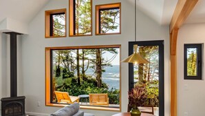 A spacious room with large windows, a fireplace, and a view of the ocean. - Fogged Inn Cove (Ucluelet)