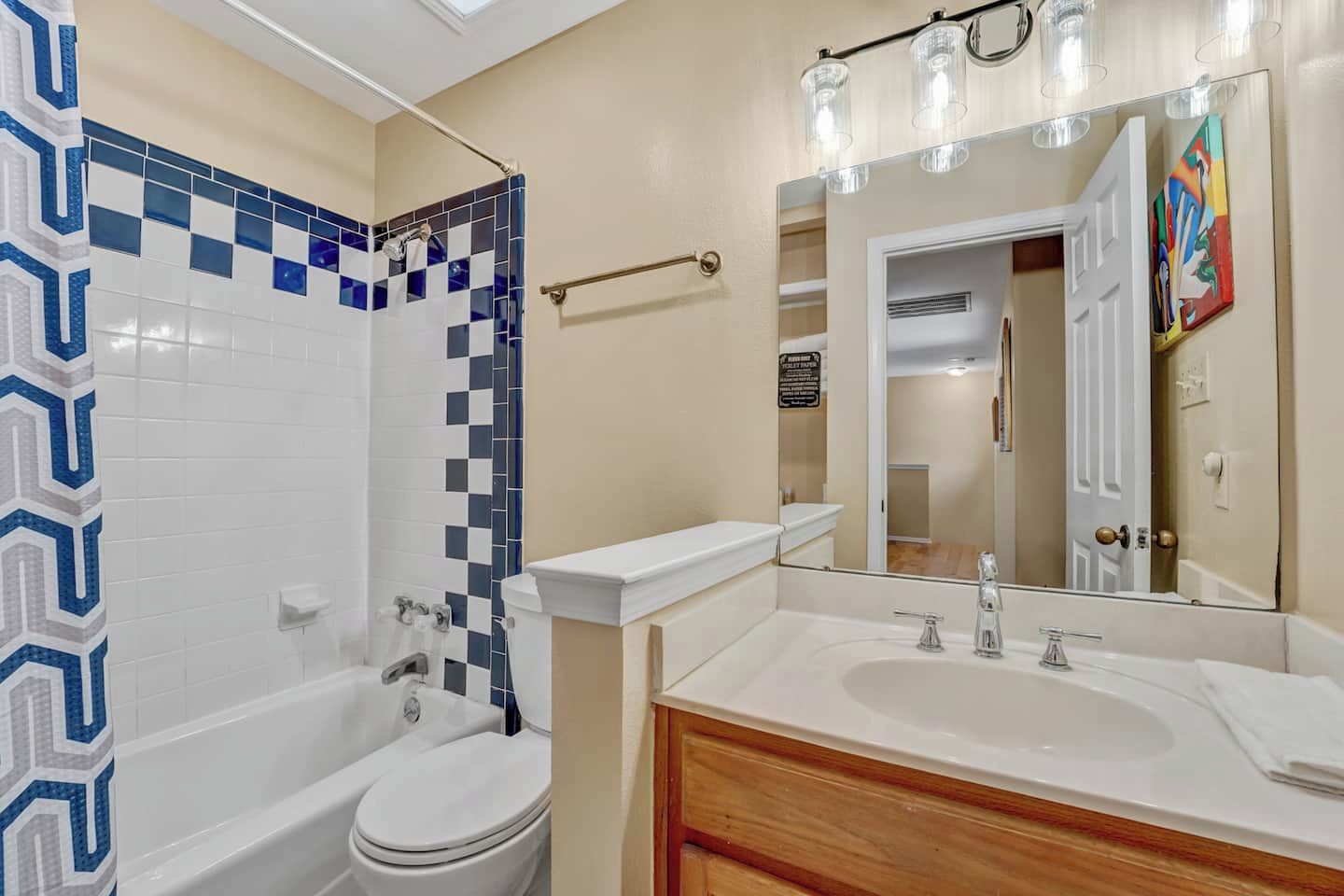 Une salle de bain avec une baignoire blanche, des toilettes et un lavabo avec un miroir au-dessus.