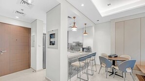 Una cocina moderna con una isla central, taburetes de bar e iluminación colgante.