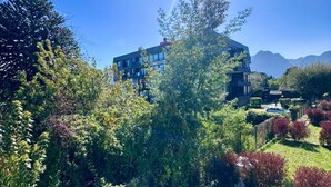 A modern building with multiple floors, surrounded by lush greenery and a clear sky. - Pucón CENTRO - Steps away from Casino ENJOY - Apartment NEW - A/C - Volcano View (Pucon)