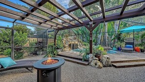 A covered outdoor area with a fire pit, seating, and a small waterfall. - Maison Bohème - Adults Only With Pool (Sarasota)