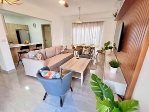 Ein modernes Wohnzimmer mit Sofa, Couchtisch und Essbereich.