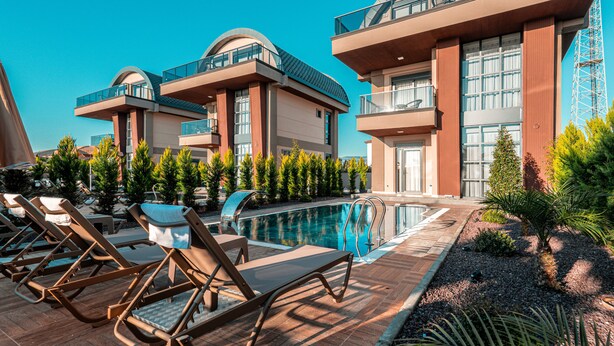 A modern hotel with a pool, sun loungers, and a well-maintained garden. - Palmera Beach Villas (Alanya)