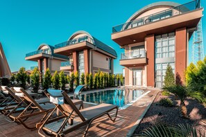 A modern hotel with a pool, sun loungers, and a well-maintained garden. - Palmera Beach Villas (Alanya)