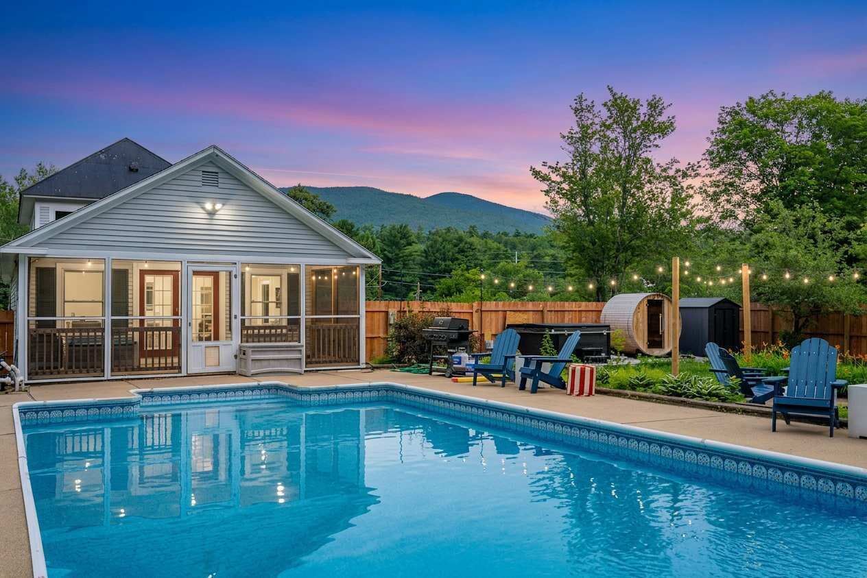 A swimming pool with a covered patio, deck chairs, and a barbecue area.