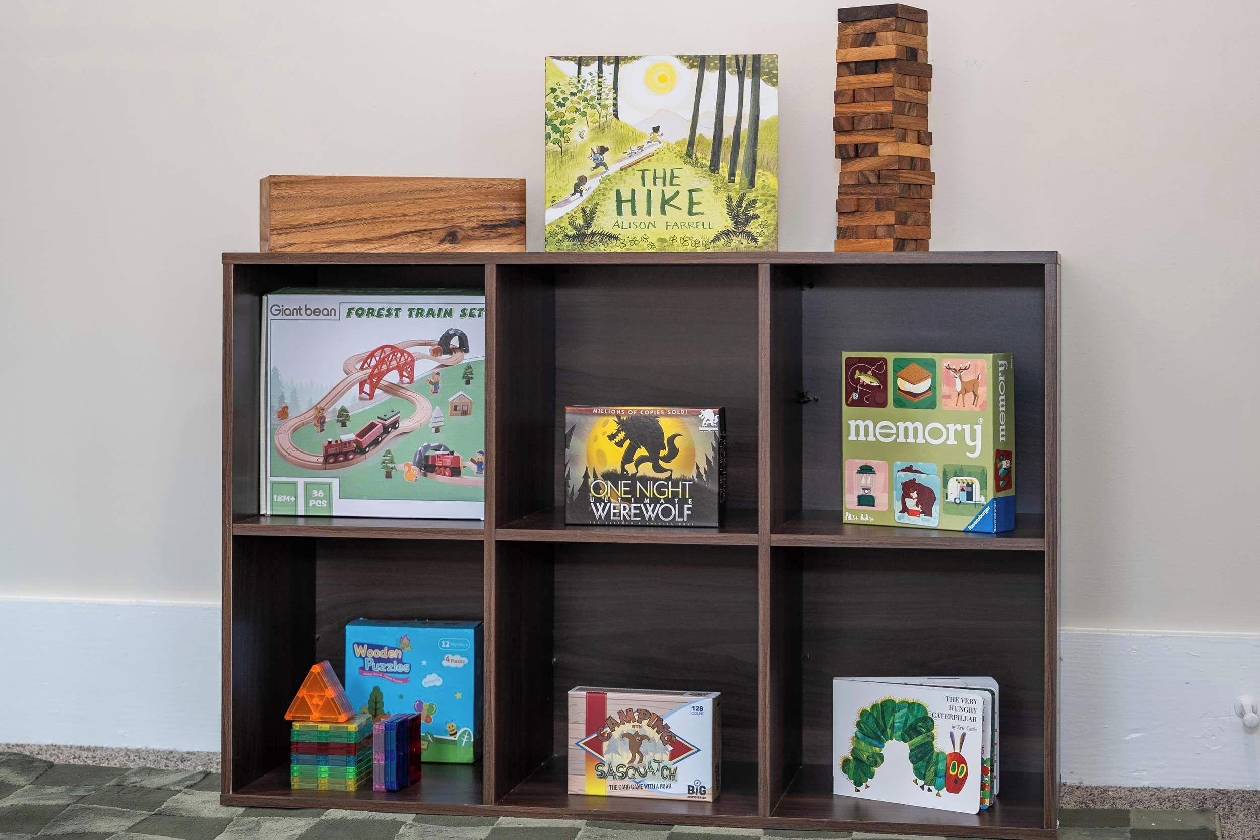 Une bibliothèque contenant divers livres et jouets pour enfants.