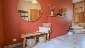 A hallway with a wooden bench, a round mirror, and a potted plant. - Rives de Seine - NEUVILLE SUR SEINE (NEUVILLE SUR SEINE)