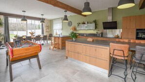 A modern kitchen with a central island, wooden cabinets, and pendant lighting. - Rives de Seine - NEUVILLE SUR SEINE (NEUVILLE SUR SEINE)