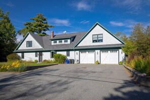 A two-story house with a garage, a chimney, and a satellite dish. - Spacious 5BR Home in Center of MDI [Loons Landing] (Mount Desert)
