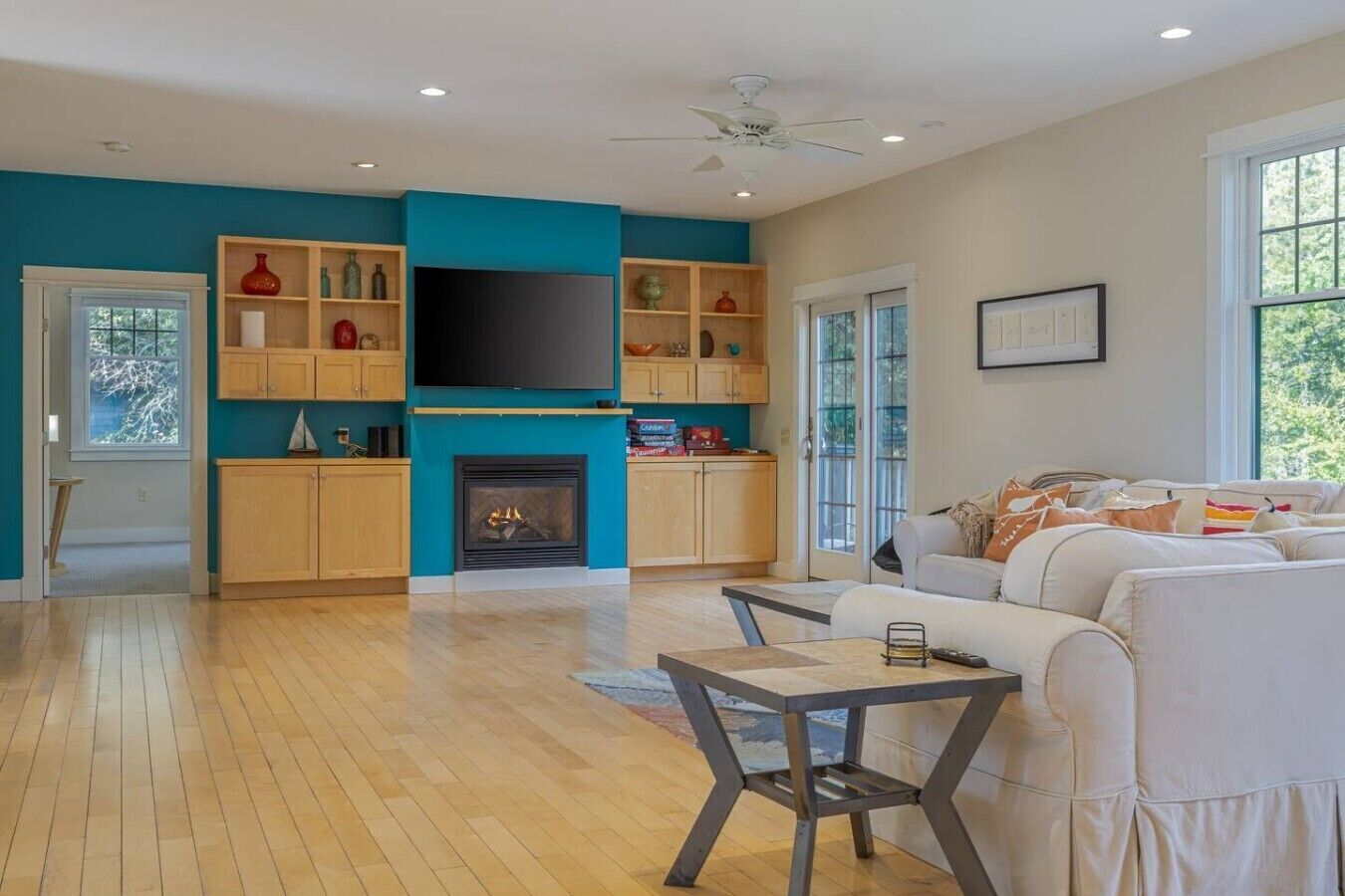 A modern living room with a fireplace, a television, and a sofa.
