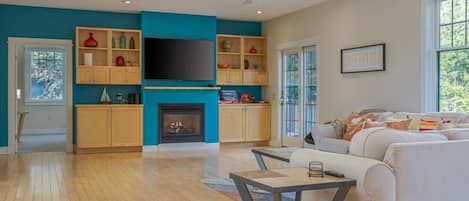 A modern living room with a fireplace, a television, and a sofa.