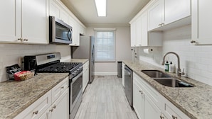 A kitchen with white cabinets, a stainless steel stove, a microwave, and a dishwasher. - Comfortable & Quiet 3BR Home Near Downtown ATL (Atlanta)