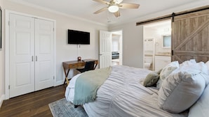A bedroom with a bed, a desk, a chair, a television, and a wardrobe. - Comfortable & Quiet 3BR Home Near Downtown ATL (Atlanta)