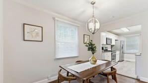 A dining area with a wooden table and chairs, a vase with a plant, and a chandelier. - Comfortable & Quiet 3BR Home Near Downtown ATL (Atlanta)