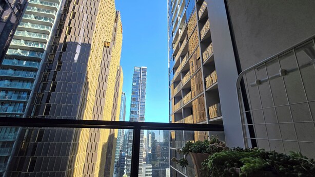 Ein hoch aufragendes Gebäude mit modernem Design, das mehrere Balkone und große Fenster aufweist.