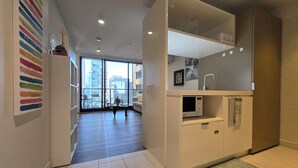 Eine moderne Wohnung mit Küchenbereich, großen Fenstern und Blick auf die Stadt.