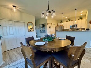 A dining area with a round wooden table, four chairs, and a chandelier. - Tucson Mountain & Wildlife Views in Vistoso (Oro Valley)