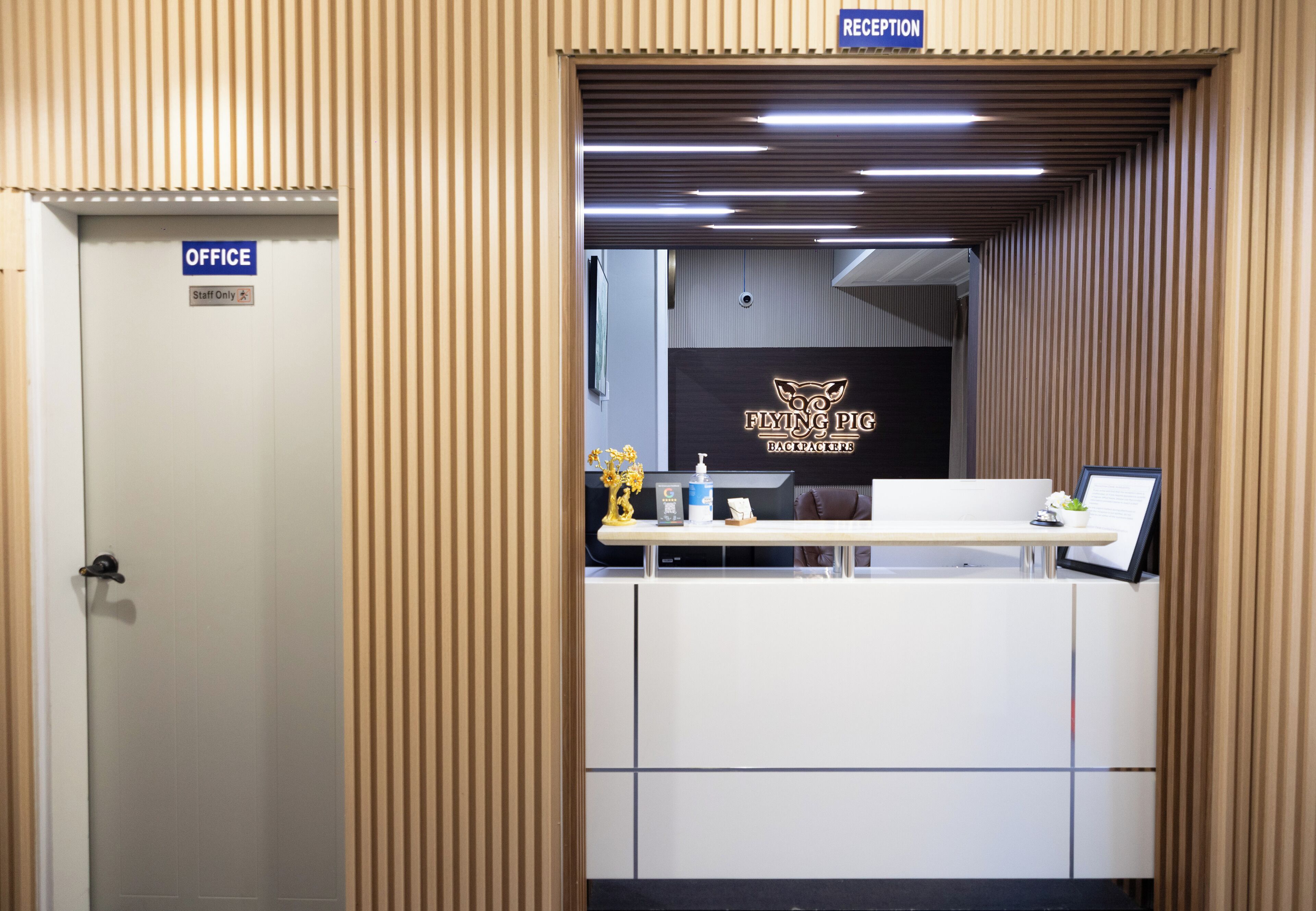 An office area with a reception desk, a sign indicating 'RECEPTION,' and a 'Staff Only' door.