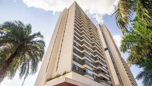 Un grand immeuble moderne, avec de nombreux balcons et un toit plat.