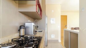 Une cuisine moderne équipée d’une cuisinière à gaz, d’une machine à café et d’un réfrigérateur.