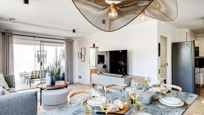 Un espace de restauration moderne avec une table en marbre dressée pour un repas, entourée de sièges confortables.